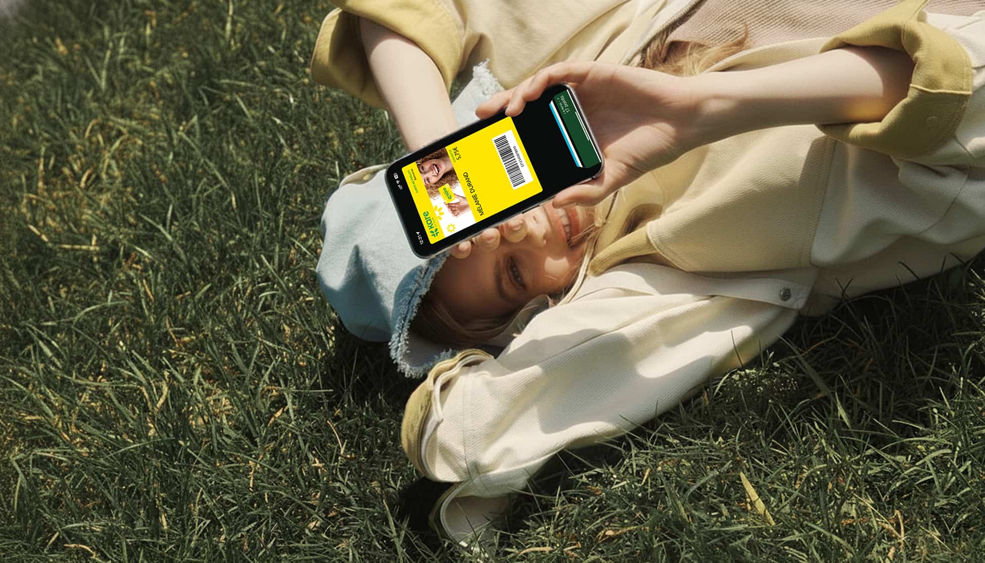 JEUNE FEMME TELEPHONE DEVANT VISAGE COUCHER SUR LA PRAIRIE